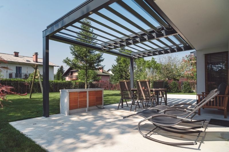 Open-roof pergola over a home extension with chairs