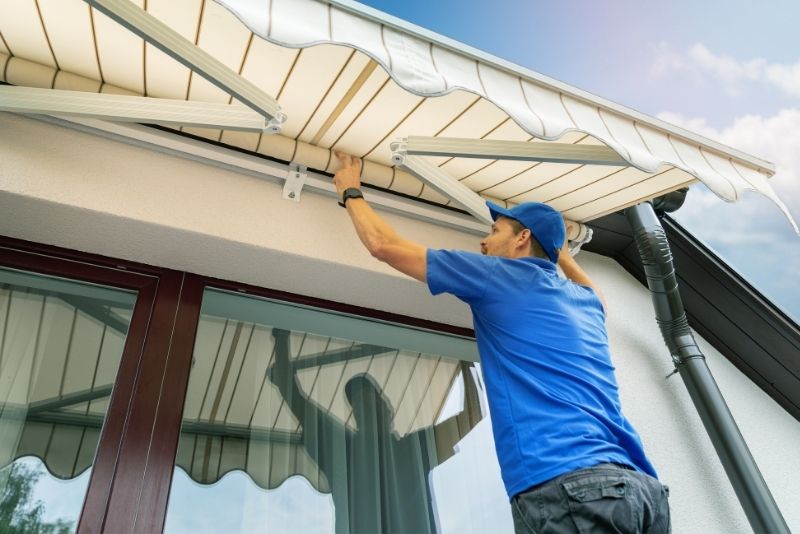 A builder installing an awning on a building